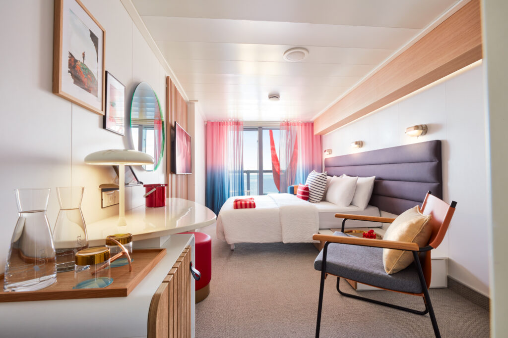 Experience Virgin Voyages' Sea Terrace cabin, a modern sanctuary featuring ocean views, sleek decor, and a signature red hammock for the ultimate luxury escape.