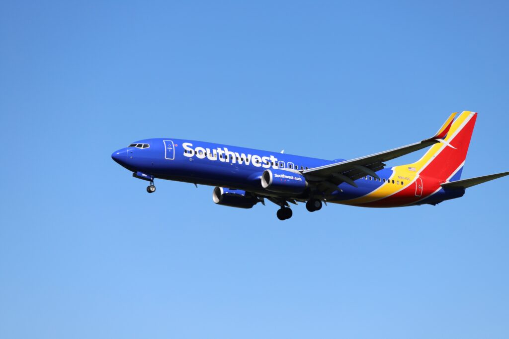 Southwest Airlines Boeing 737 aircraft in flight against a clear blue sky, representing upcoming 2025 baggage policy and fare structure changes.