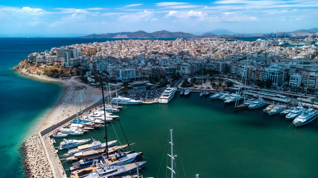 Aerial view of a marina, coastline, and urban waterfront along the Athens Riviera in Greece.