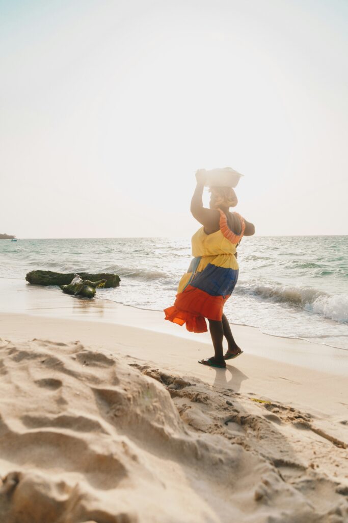 Palenquera woman walking along a beach in Cartagena, Colombia